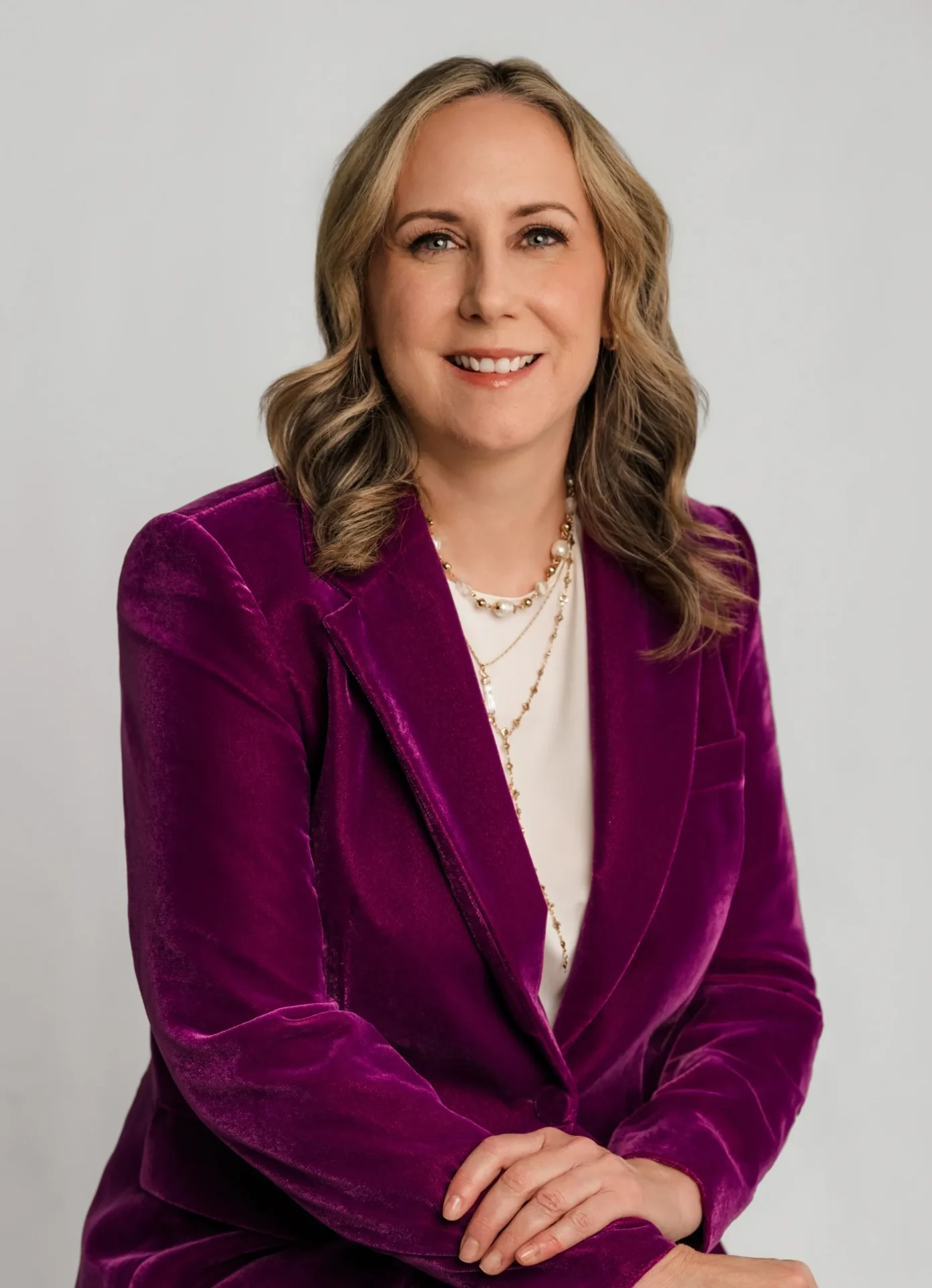 A woman in a purple velvet suit posing for a photo.